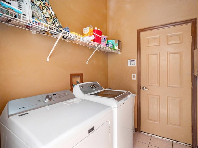 laundry room with washer and dryer and light tile patterned flooring