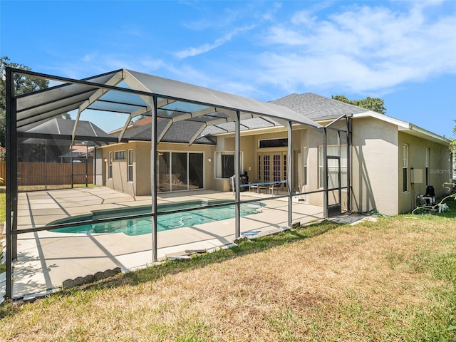 view of pool featuring a lawn, glass enclosure, french doors, and a patio