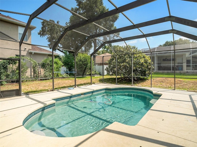 view of swimming pool with a lawn, a patio area, and glass enclosure