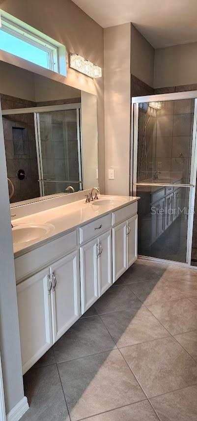 bathroom with tile patterned floors, a sink, and double vanity