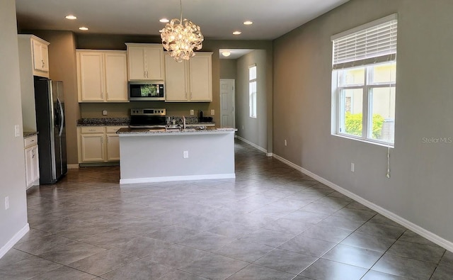 kitchen with hanging light fixtures, a chandelier, light tile patterned floors, stainless steel appliances, and a center island with sink