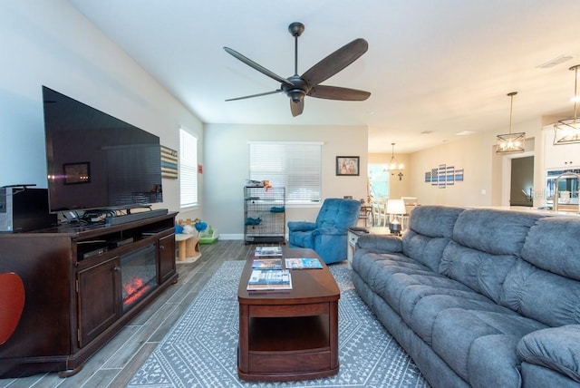 living room featuring ceiling fan with notable chandelier