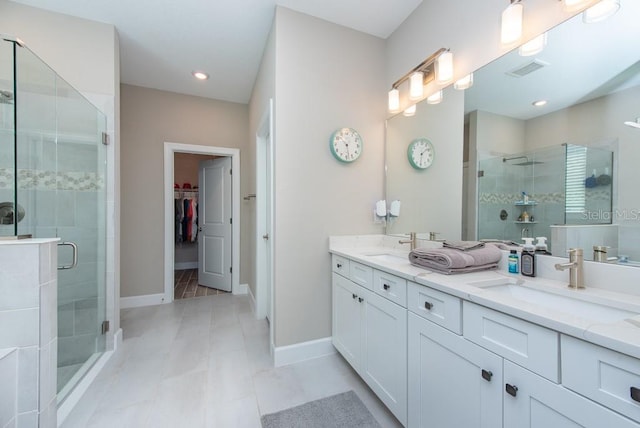 bathroom featuring double sink vanity, walk in shower, and tile patterned flooring