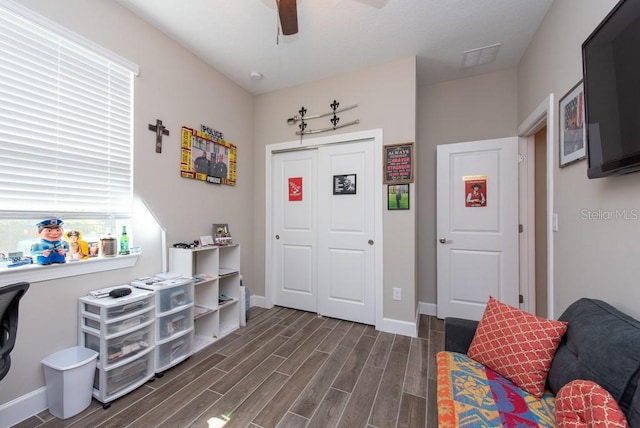 interior space with ceiling fan and dark hardwood / wood-style floors