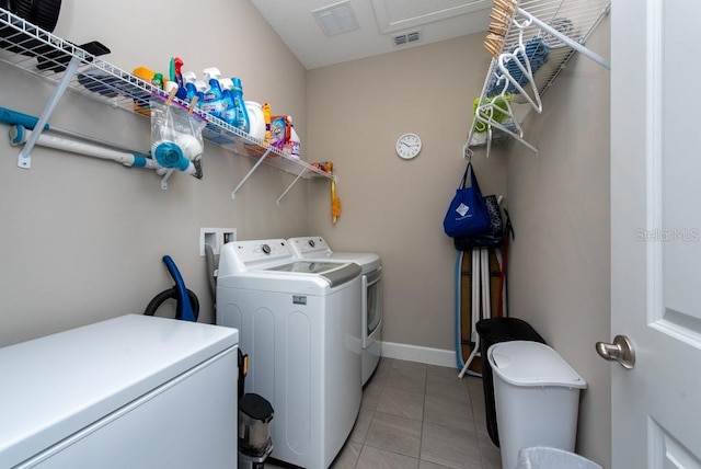 laundry area with washing machine and clothes dryer and tile patterned flooring