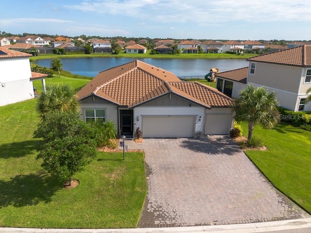 mediterranean / spanish house with a water view, a garage, and a front yard