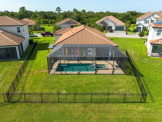 back of house with a yard and a fenced in pool