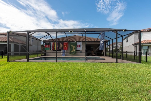 rear view of house with a lanai, a patio, a yard, and a fenced in pool