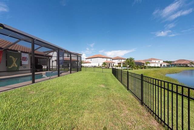 view of yard with a water view, glass enclosure, and a fenced in pool