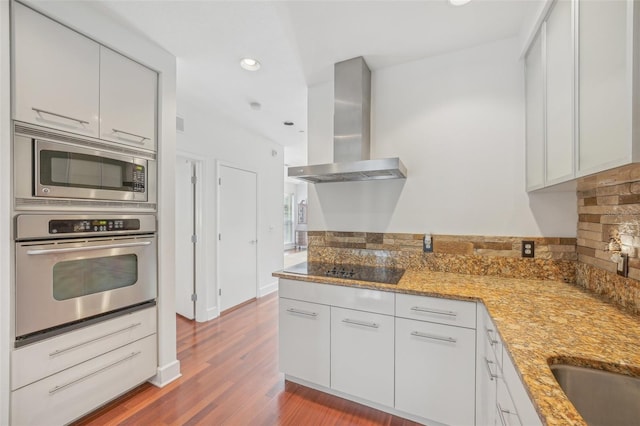 kitchen featuring white cabinetry, appliances with stainless steel finishes, light stone counters, and island range hood