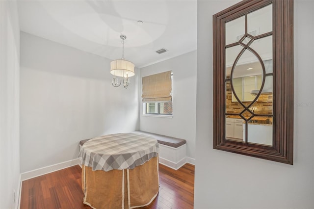 dining area with a chandelier and dark hardwood / wood-style flooring