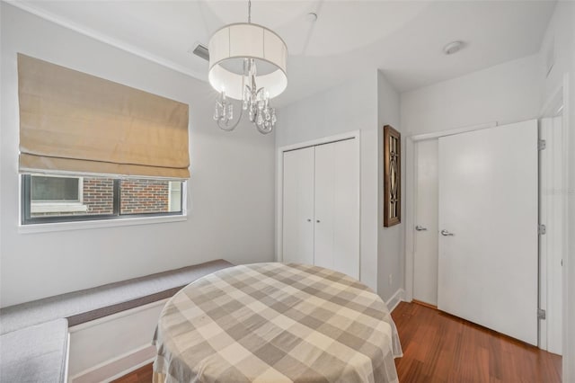 bedroom featuring dark hardwood / wood-style flooring and an inviting chandelier