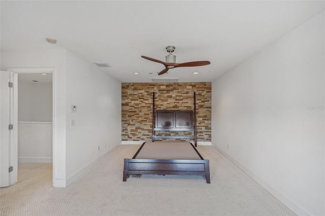 workout room featuring ceiling fan, light carpet, and a wood stove