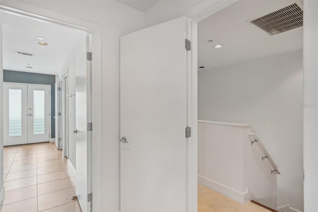 hallway with french doors and light tile patterned flooring