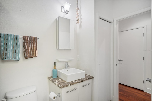 bathroom featuring vanity, hardwood / wood-style floors, and toilet