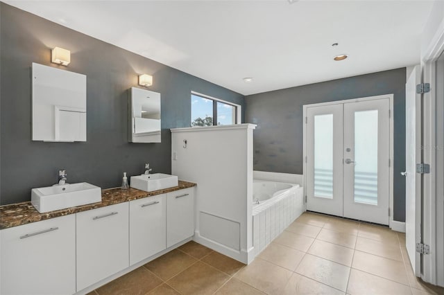 bathroom with french doors, vanity, a relaxing tiled tub, and tile patterned flooring