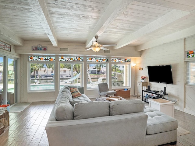 living room with beamed ceiling, a wealth of natural light, and wooden ceiling