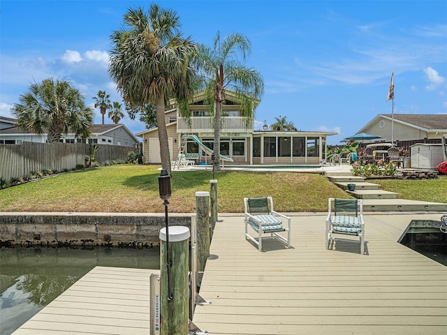 dock area featuring a lawn, a balcony, and a water view