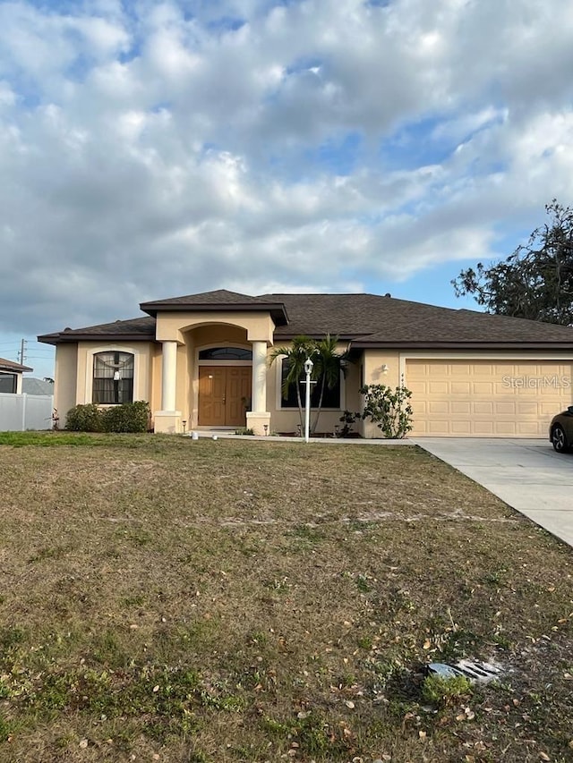 view of front of property featuring a front yard and a garage