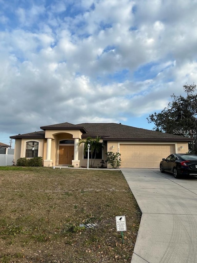 view of front of property with a garage and a front lawn