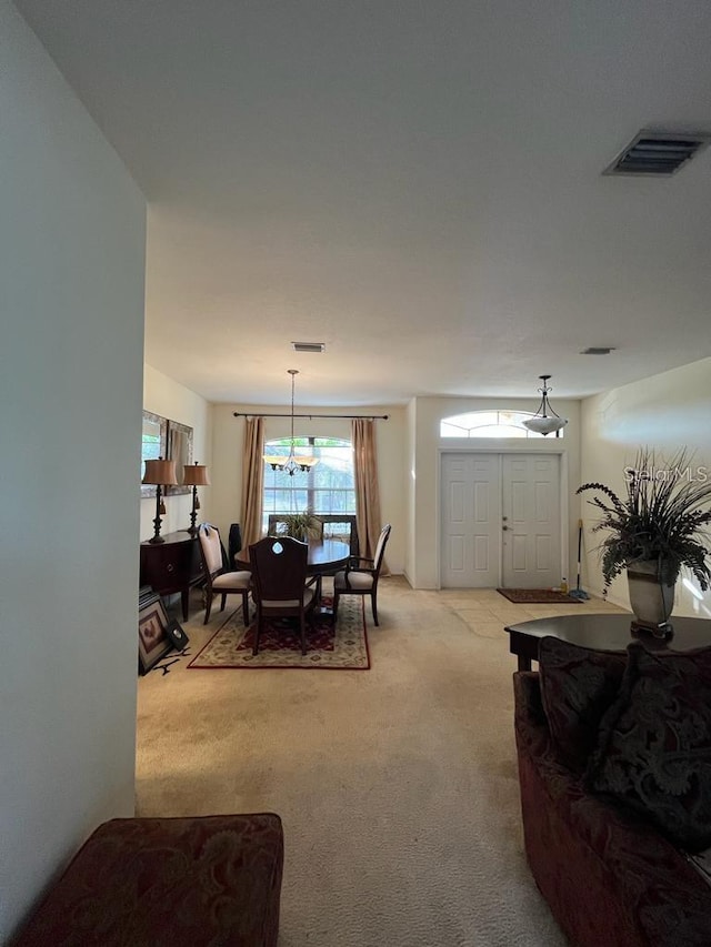 carpeted dining room featuring a notable chandelier