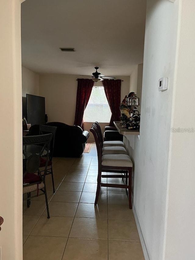 tiled dining space featuring ceiling fan