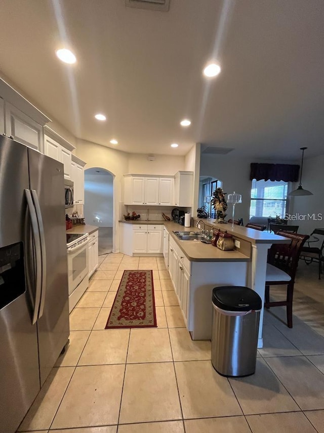 kitchen with white cabinets, light tile patterned floors, sink, and appliances with stainless steel finishes