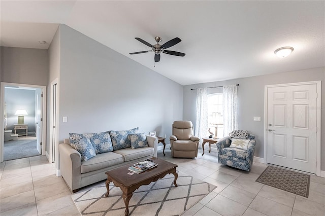 living room with ceiling fan, light tile patterned flooring, and lofted ceiling