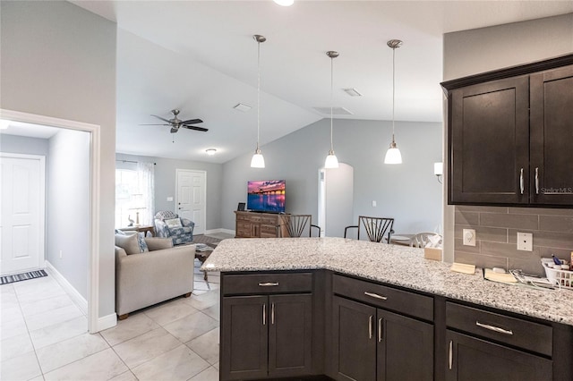 kitchen with ceiling fan, tasteful backsplash, dark brown cabinetry, and vaulted ceiling