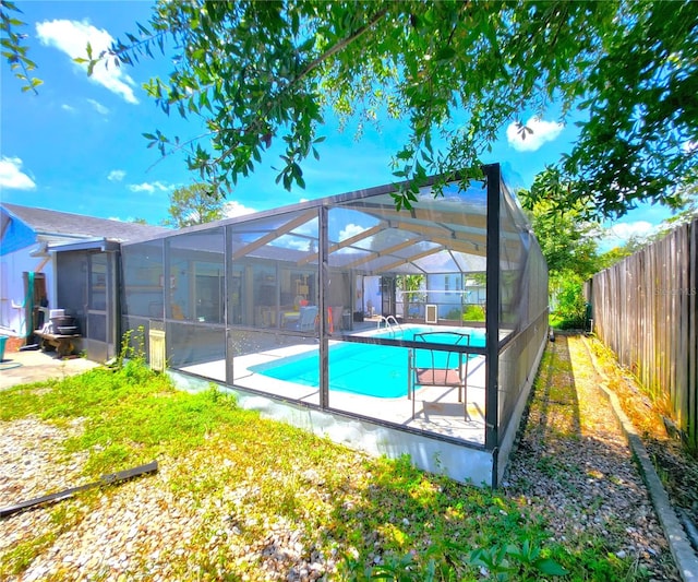 back of house with a lanai, a fenced in pool, and a patio area