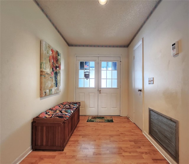 doorway featuring light hardwood / wood-style floors and a textured ceiling