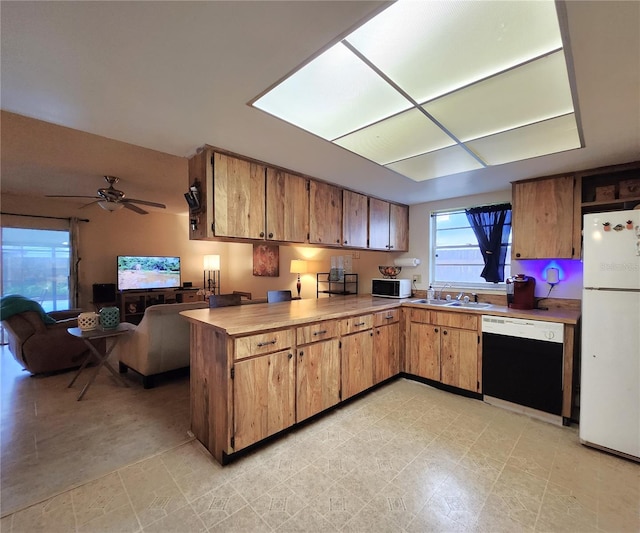 kitchen with ceiling fan, sink, white fridge, and black dishwasher