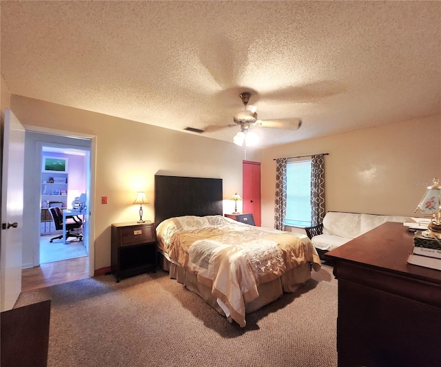 bedroom with ceiling fan, a textured ceiling, and carpet flooring