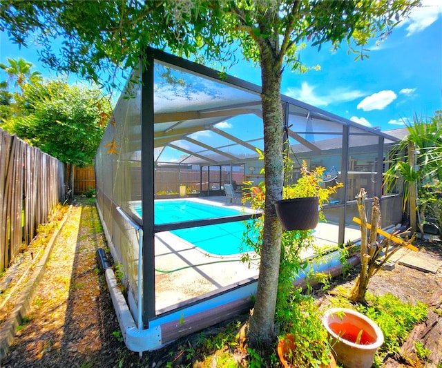 view of pool featuring a fenced in pool, a patio area, glass enclosure, and a fenced backyard