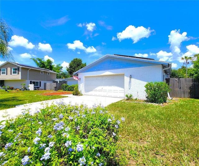 exterior space featuring concrete driveway, brick siding, a lawn, and fence