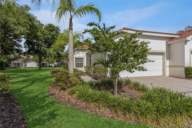 view of front of home featuring stucco siding, a front yard, a garage, driveway, and a tiled roof