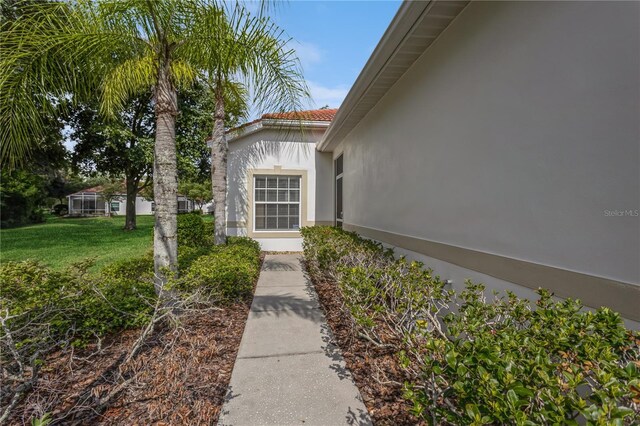 view of exterior entry featuring a lawn