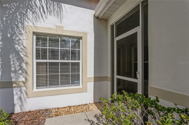 view of exterior entry with stucco siding