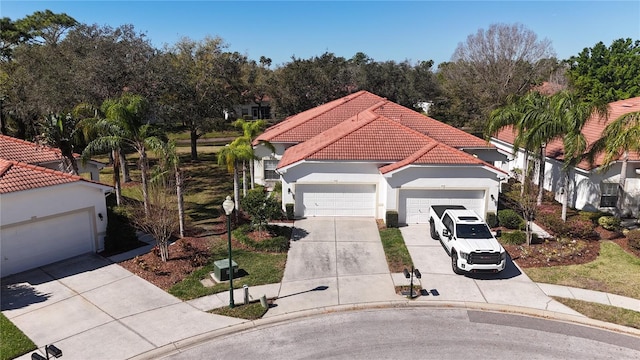 view of front of home featuring a garage, driveway, a tile roof, and stucco siding