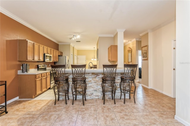 kitchen featuring light tile patterned floors, a breakfast bar area, stainless steel appliances, light countertops, and crown molding