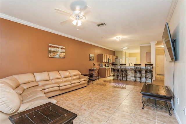 living room featuring light tile patterned floors, visible vents, a ceiling fan, and ornamental molding