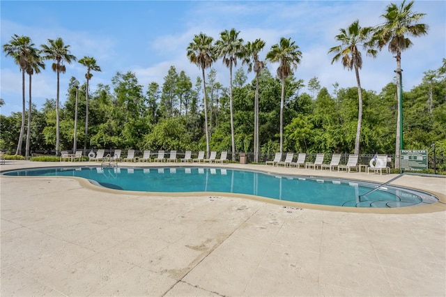 community pool featuring a patio area and fence