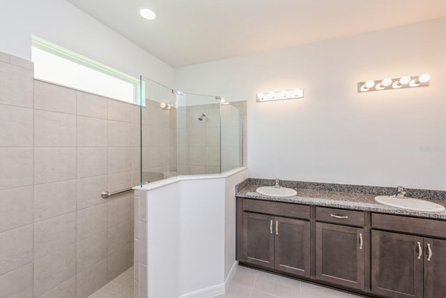 bathroom featuring vanity, tile patterned floors, and tiled shower