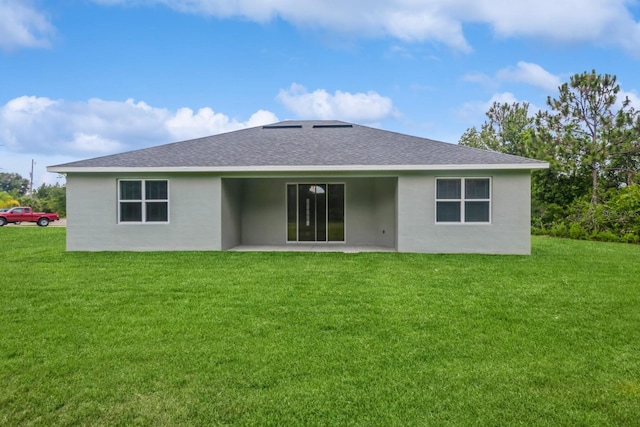 back of house with a patio and a lawn