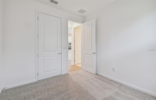 unfurnished bedroom with light colored carpet