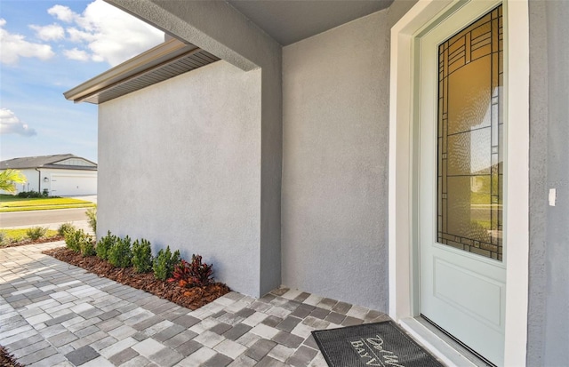 view of exterior entry featuring stucco siding