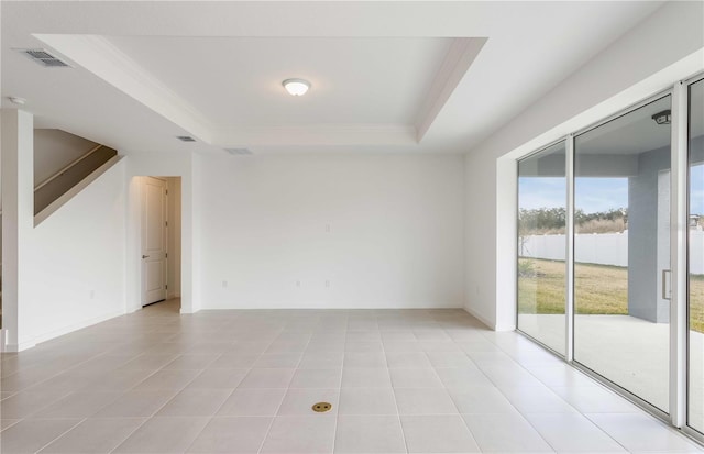 tiled spare room with a tray ceiling