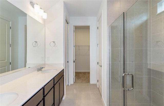 bathroom with a shower with door, vanity, and tile patterned flooring