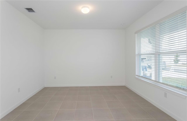 tiled empty room featuring a healthy amount of sunlight