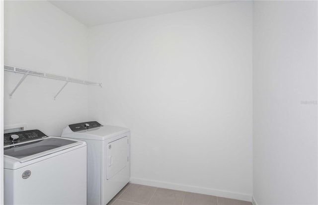 washroom with washing machine and dryer and light tile patterned flooring